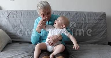 一个<strong>老奶奶</strong>带着深深的海象坐在沙发上，怀里抱着一个小孙子。